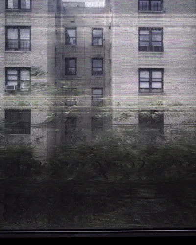 Long-exposure scanning-back photograph of an apartment building facade seen through a grime-covered window, image 1 of 8 in the Grid Dirt Glass series.