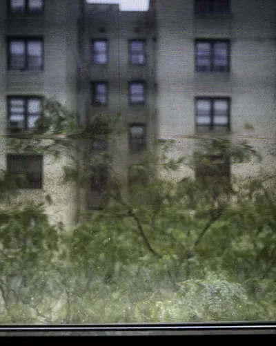 Long-exposure scanning-back photograph of an apartment building facade seen through a grime-covered window, image 3 of 8 in the Grid Dirt Glass series.