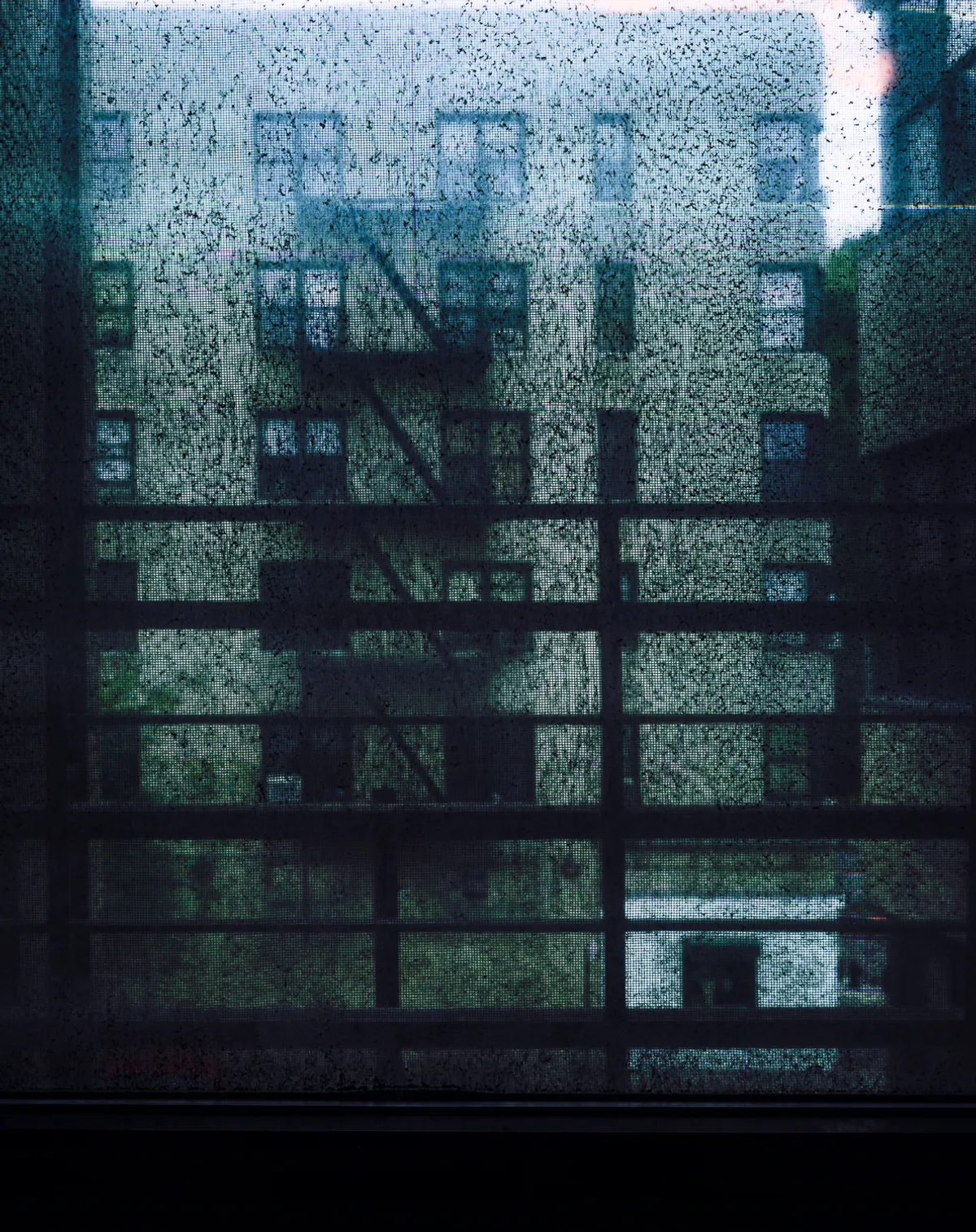 Long-exposure scanning-back photograph of an apartment building facade seen through a grime-covered window, image 4 of 8 in the Grid Dirt Glass series.