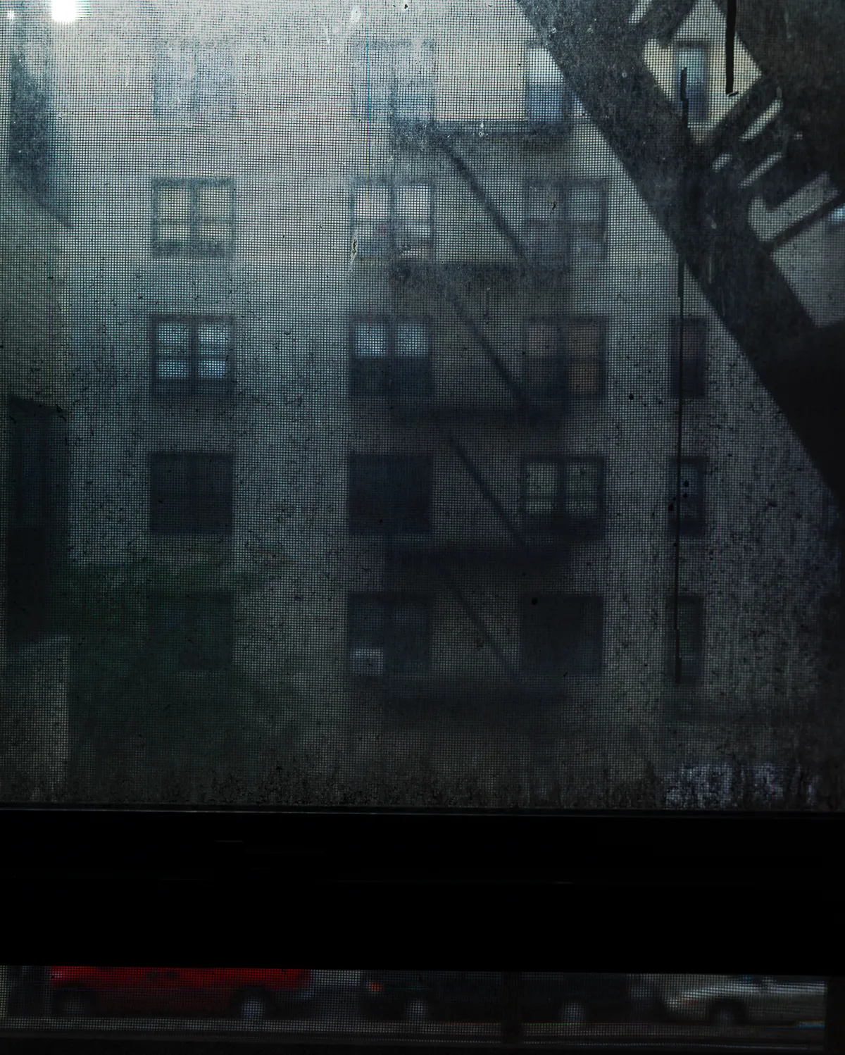 Long-exposure scanning-back photograph of an apartment building facade seen through a grime-covered window, image 6 of 8 in the Grid Dirt Glass series.